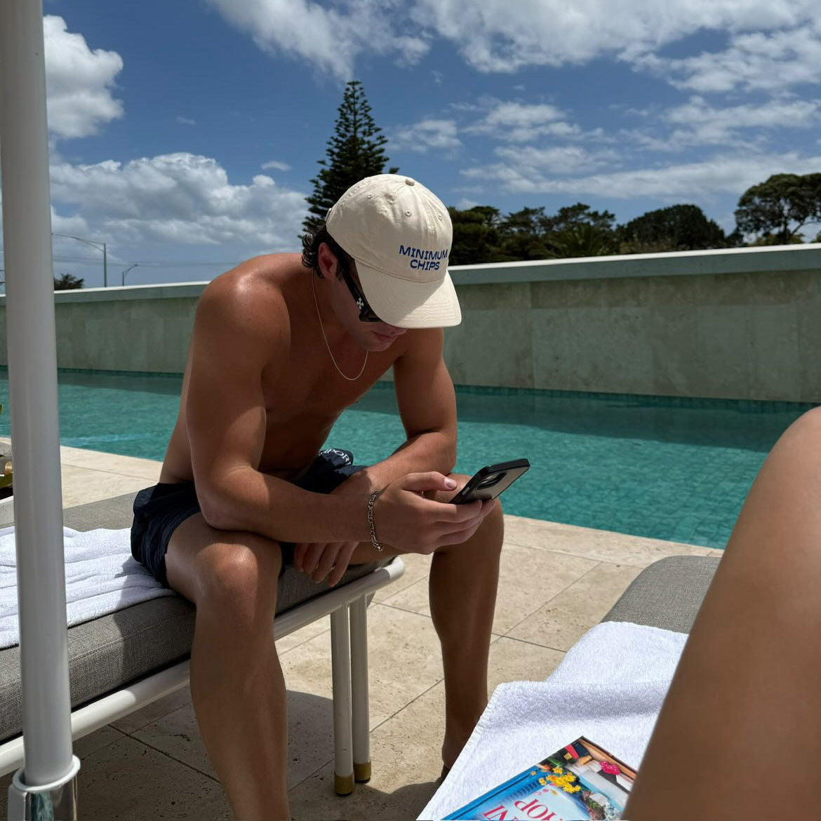 A beige baseball cap with 'MINIMUM CHIPS' embroidered in blue on the front.