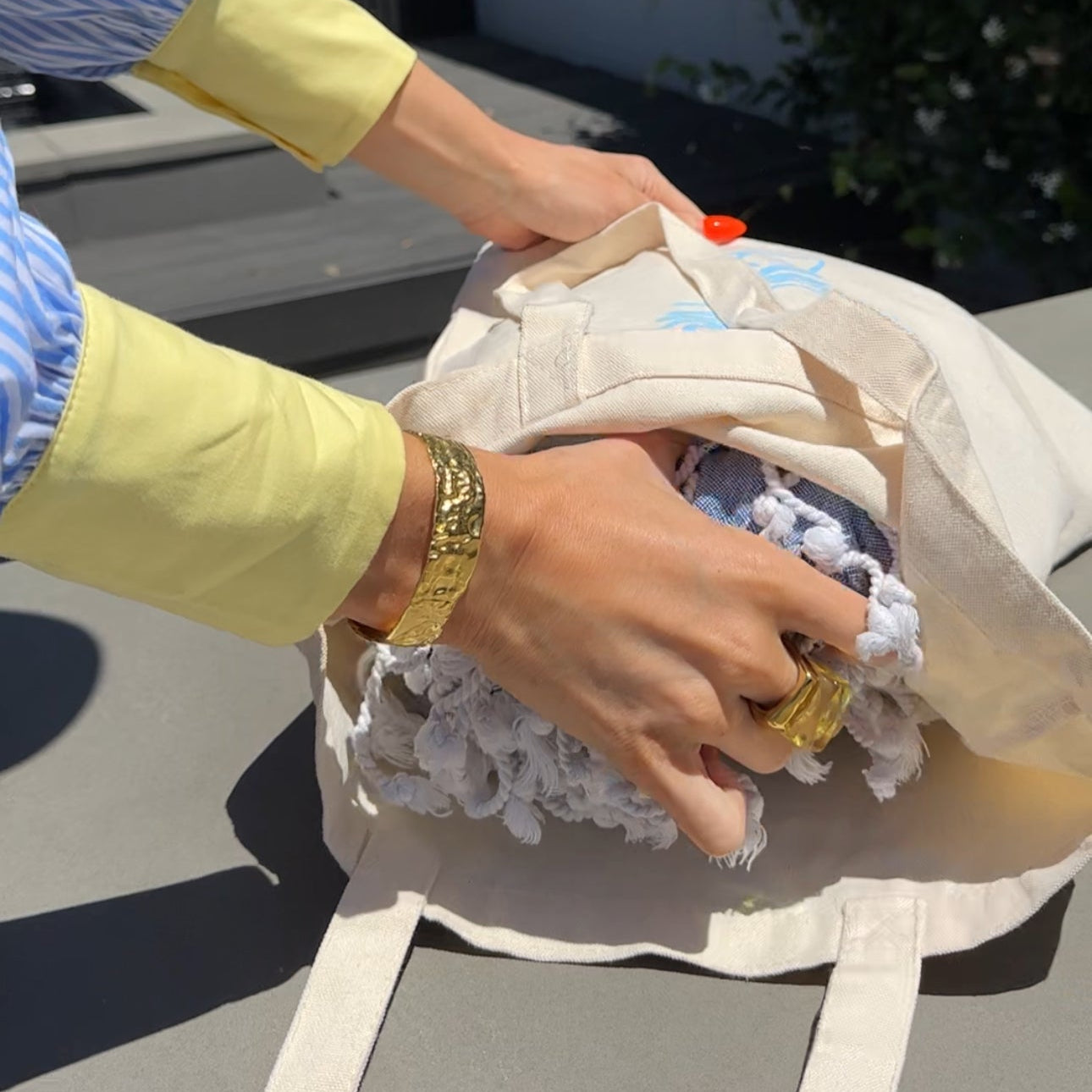 A beige cotton canvas tote bag with long straps.