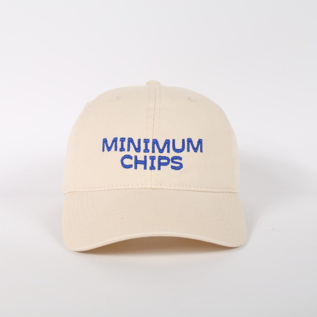 A beige baseball cap with 'MINIMUM CHIPS' embroidered in blue on the front.