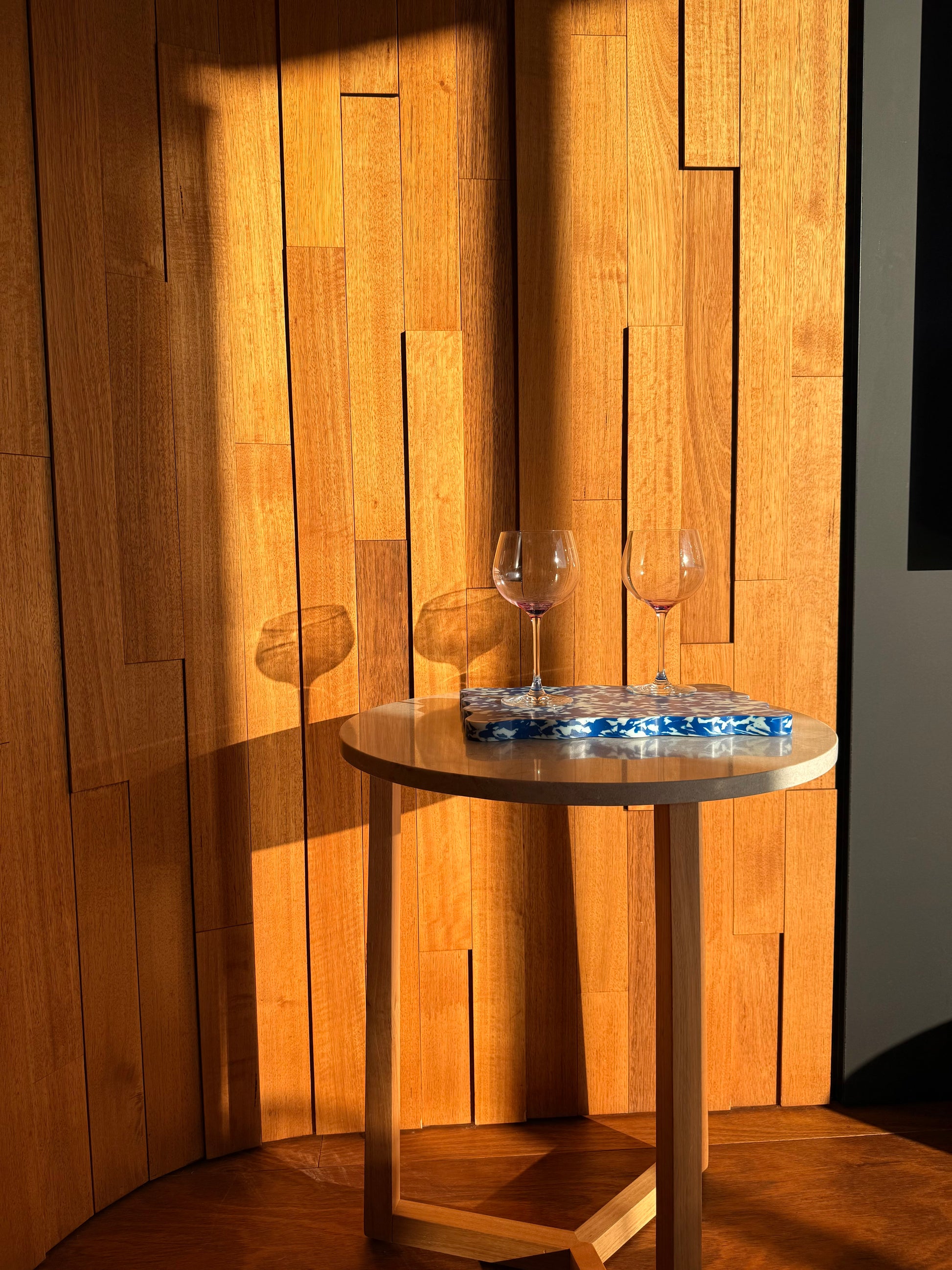 Blue and white wavy serving tray by Pinchy on round table in mid-century style home