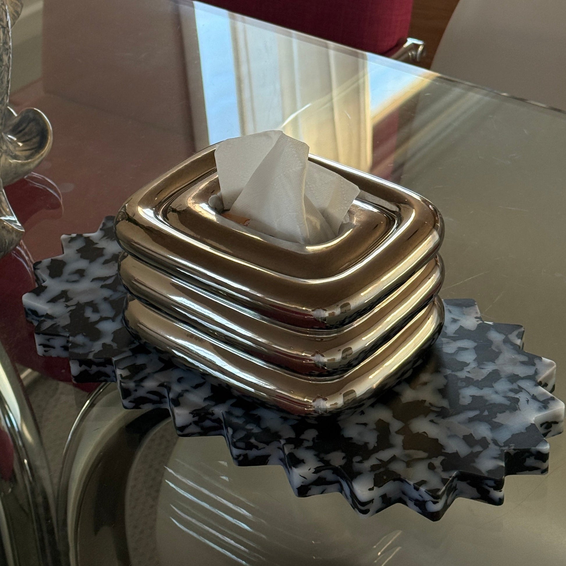 Spikey tray with chrome tissue box on top

