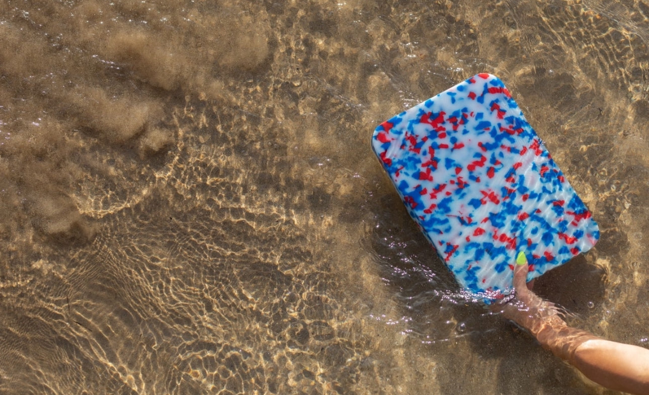 pinchy red and blue chopping board in the sandy ocean 