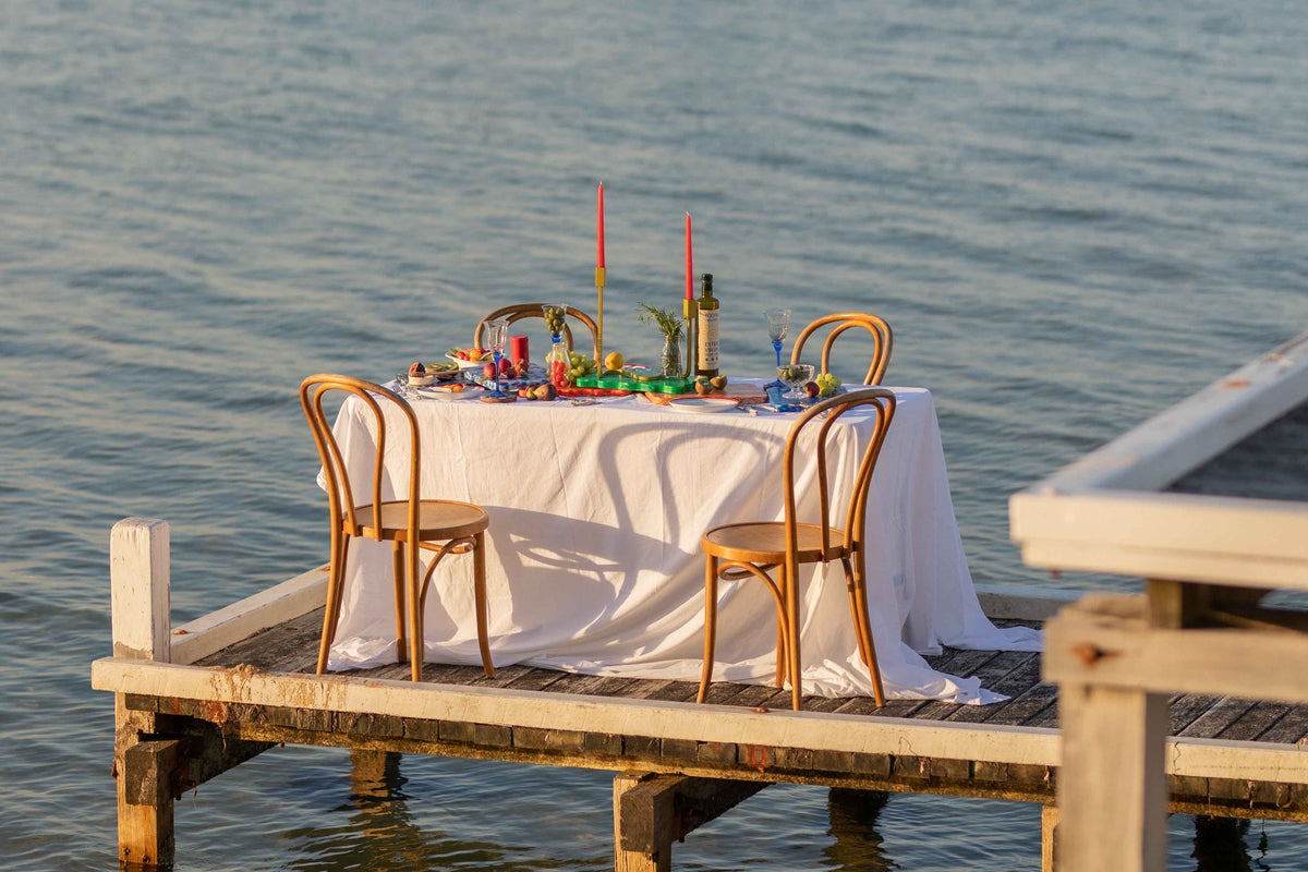 Chic editorial dining setting on the water with Pinchy chopping boards featured.