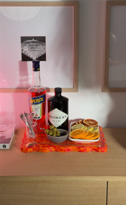 Orange and red wavy Pinchy chopping board styled as bar tray with Aperol, Hendrick’s Gin, olives and citrus slices