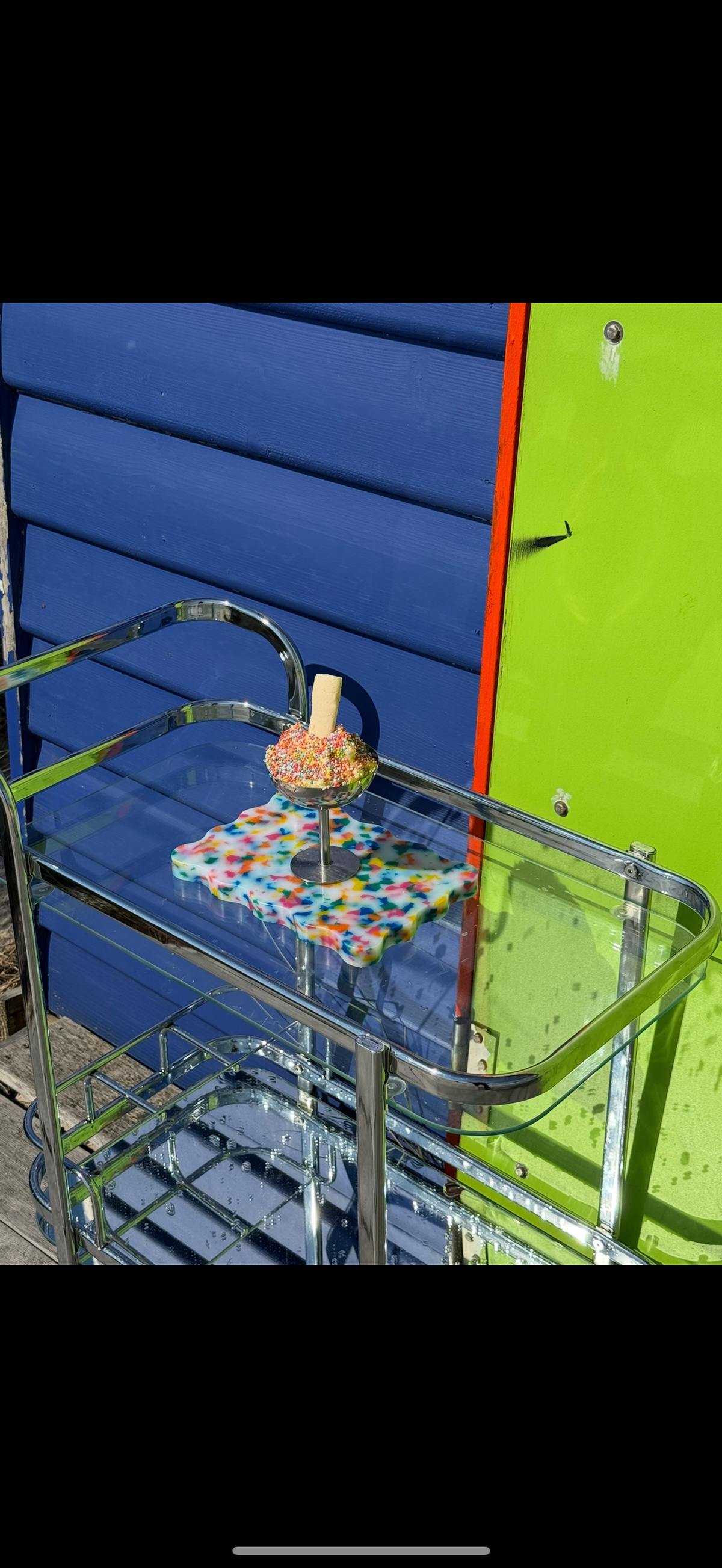 Colourful mini wavy chopping board featured on a glass bar cart.