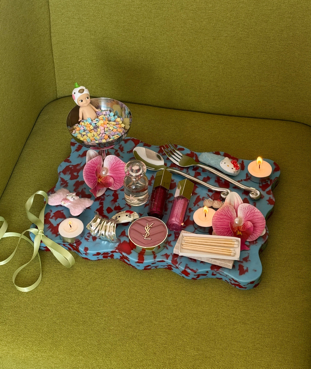 Red and blue cutting board used as a decorative scalloped tray with small items displayed. 